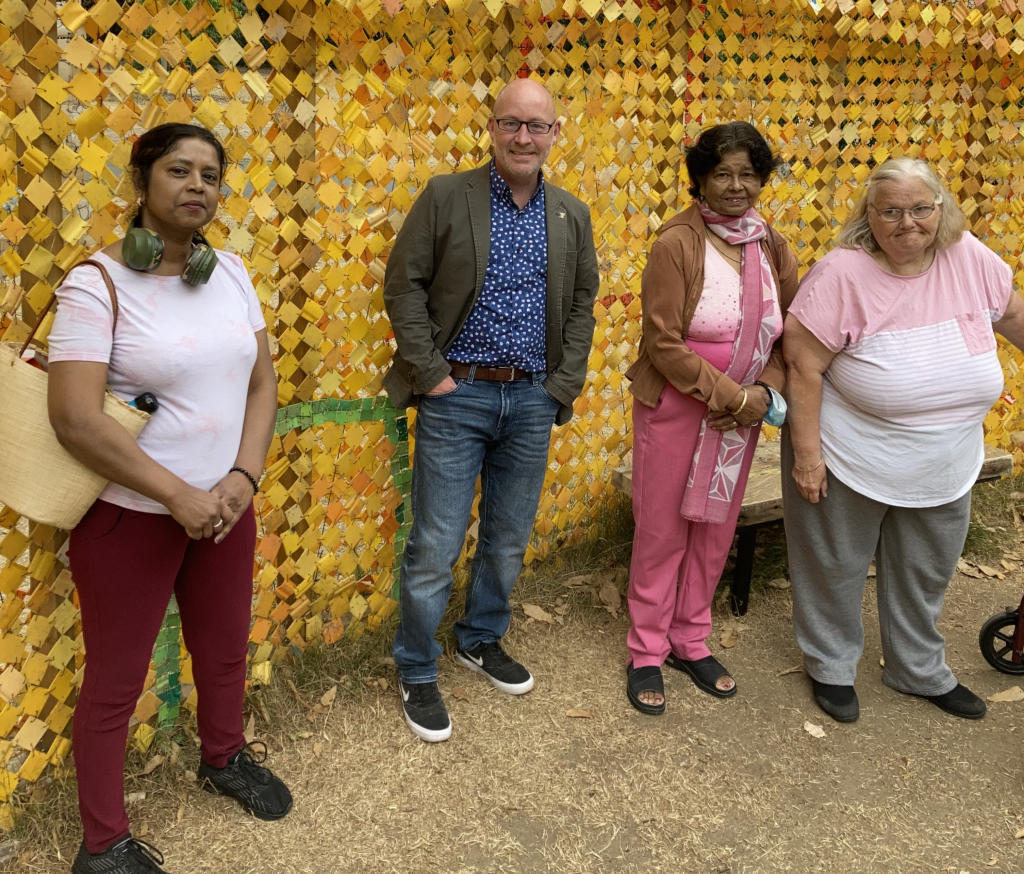 KCIL staff and members at Kew Gardens in front of a gold glittery wall