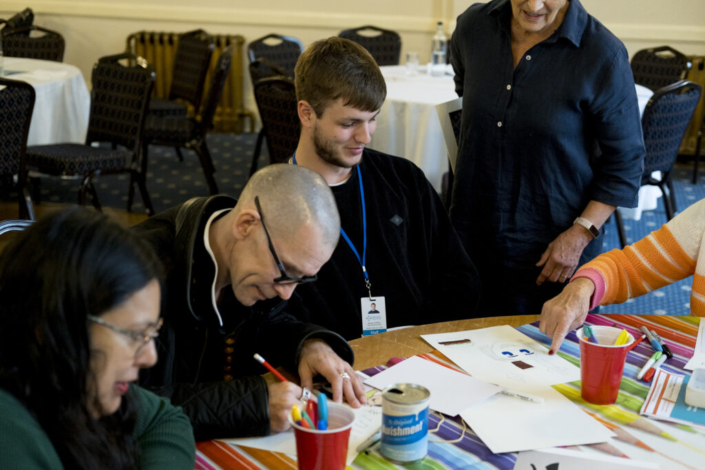 KCIL staff and members sitting at a table doing art at the KCIL conference