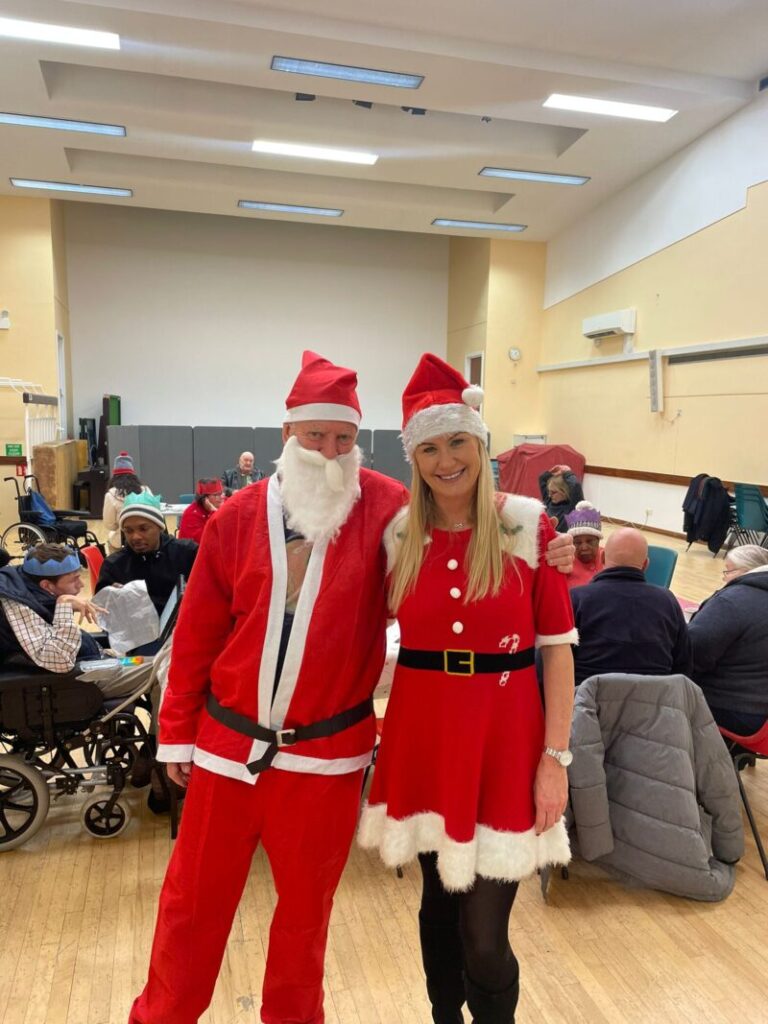 An image of a man and woman in santa costumes.