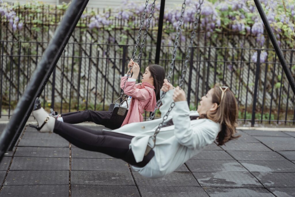 A disabled child and her carer on swings