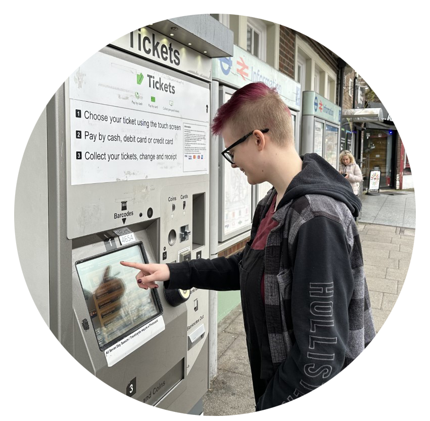 A young person looking at a ticket machine