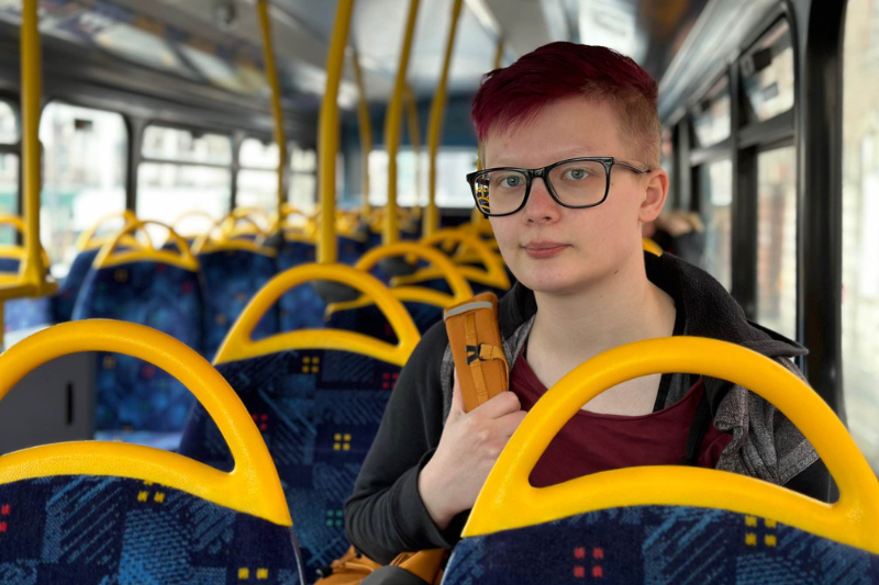 A young person sits on the bus