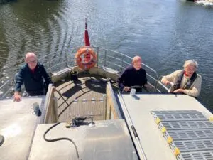 A KCIL service user drives the boat next to KCIL CEO Jason