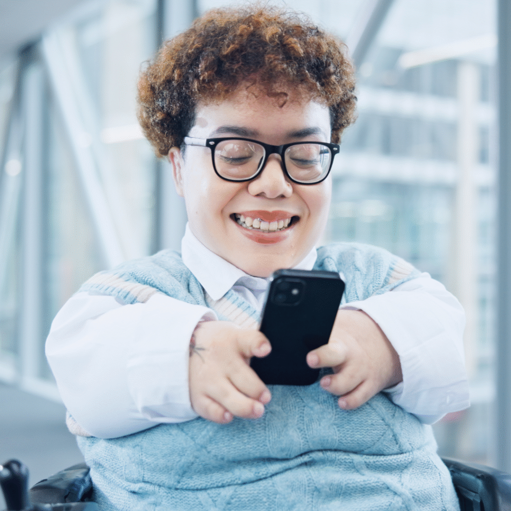 A woman with a limb difference looking at her phone
