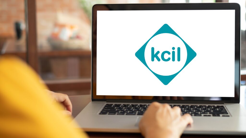 Someone in front of a laptop with a kcil logo