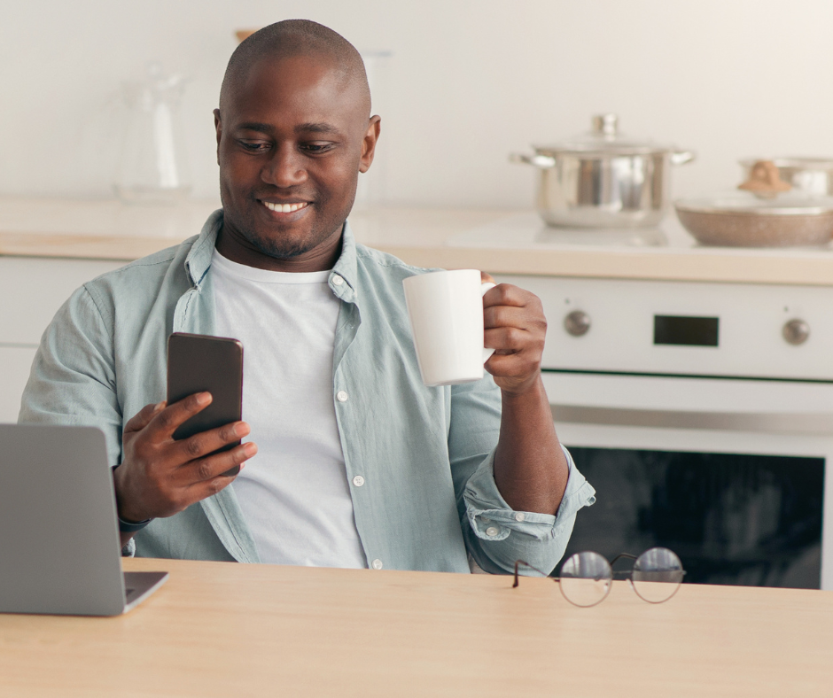 man looking at phone at kitchen table