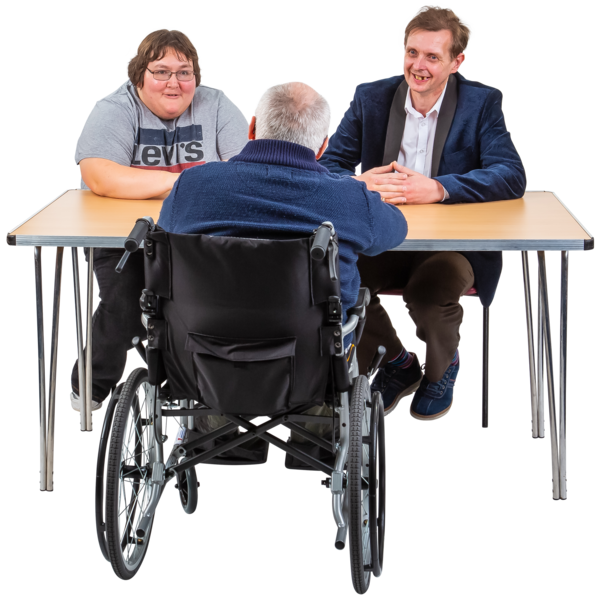 Three people at a table, one in a wheelchair, having a discussion.