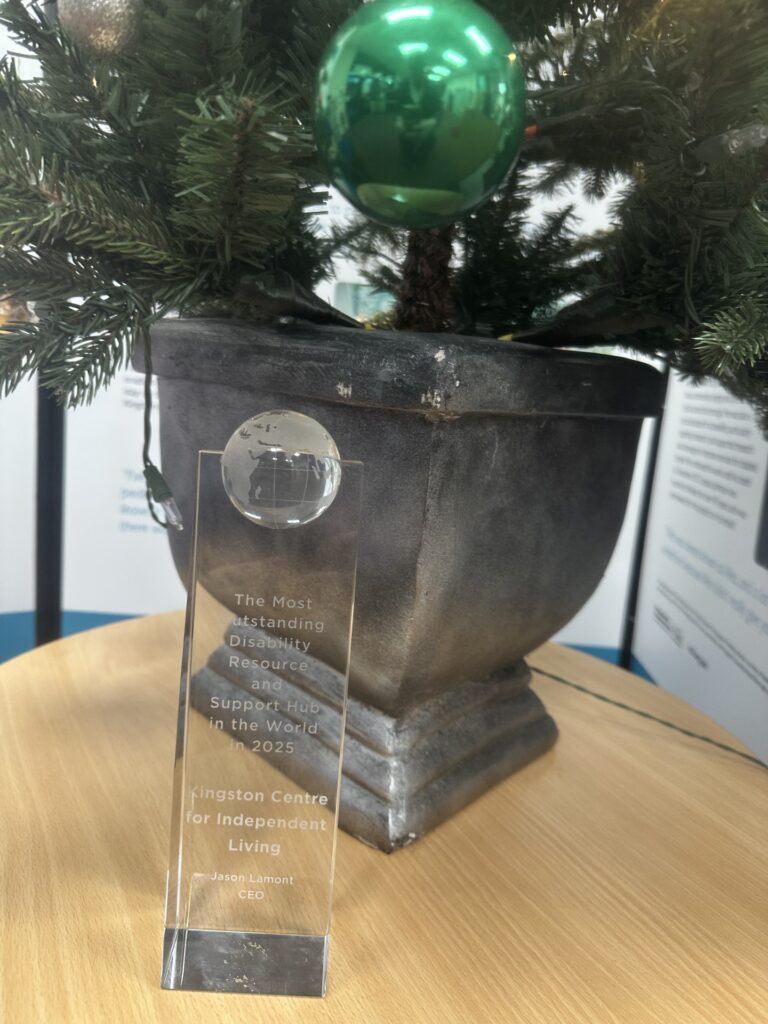 The award next to KCIL Christmas tree, it says The Most Outstanding Disability Resource and Support Hub in the Worldin 2025, Kingston Centre for Independent Living, Jason Lamont CEO