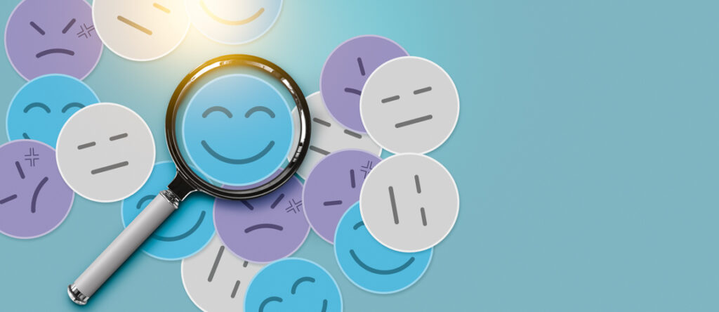 A mixture of cartoon faces, some happy some sad, and a magnifying glass