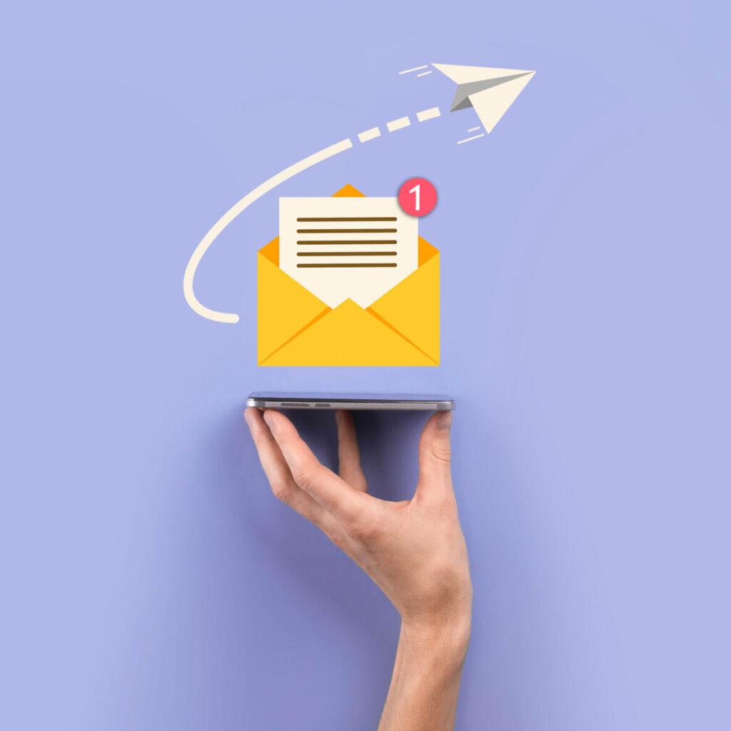 A hand holds a phone with an email icon coming out of it