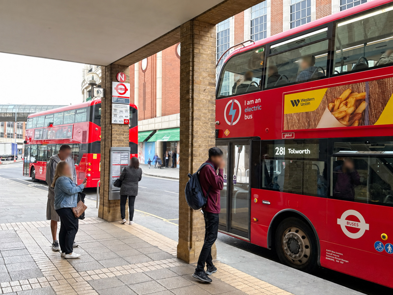 People waiting for the bus at the Wood Street bus stop in Kingston. There is a 281 bus